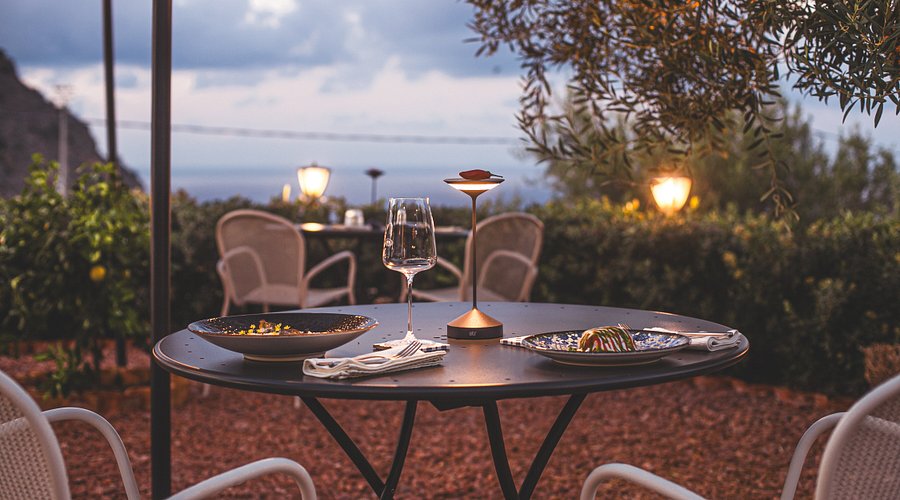 Terrazza panoramica di un ristorante con vista su Cefalù al tramonto