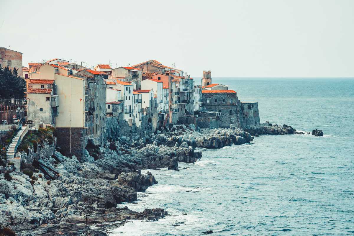 Bambini tra i 6 e i 12 anni che partecipano a un laboratorio creativo all’aperto davanti al Museo Mandralisca di Cefalù, atmosfera educativa e allegra
